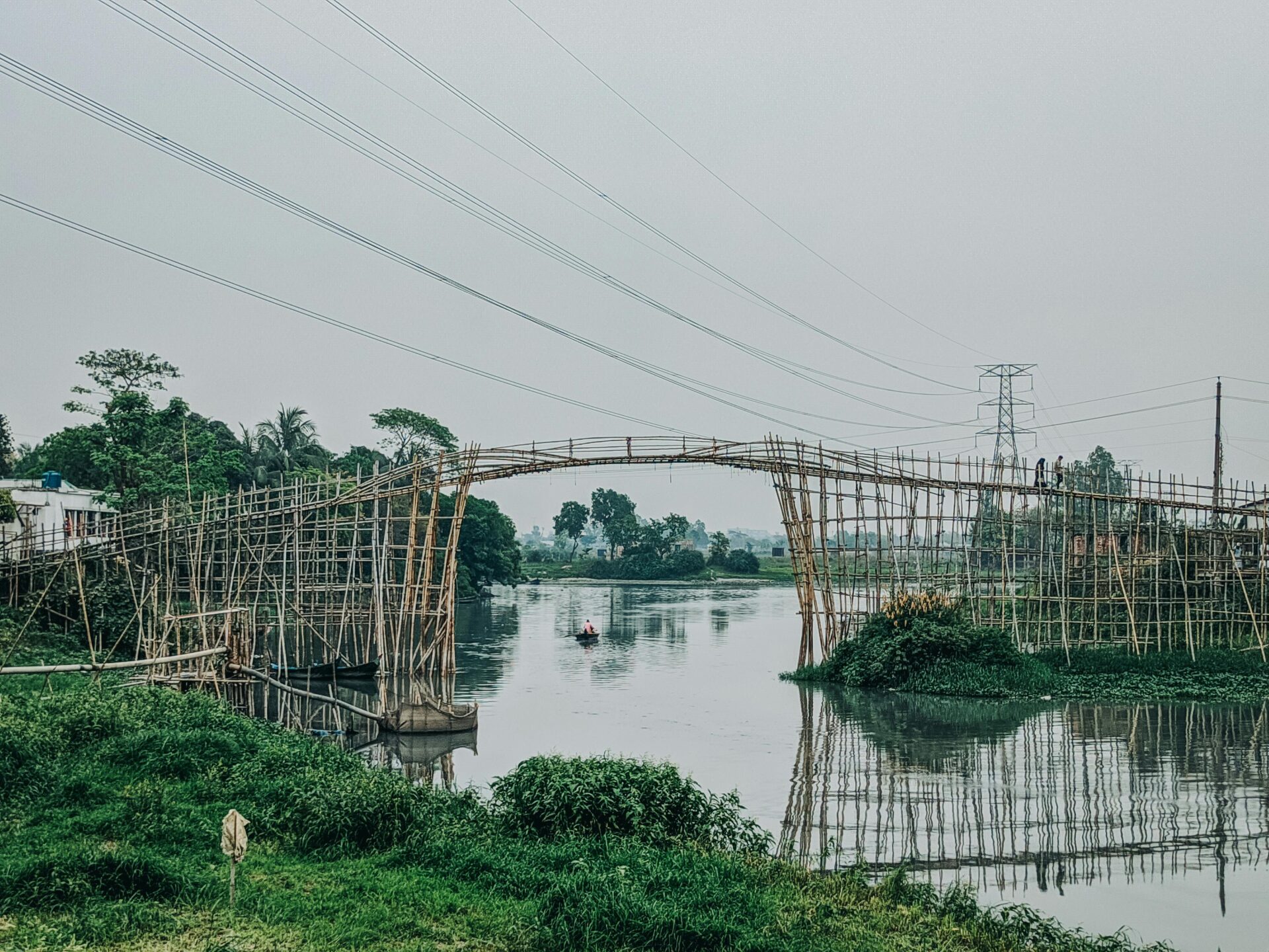 power-lines-over-wooden-footbridge-on-river