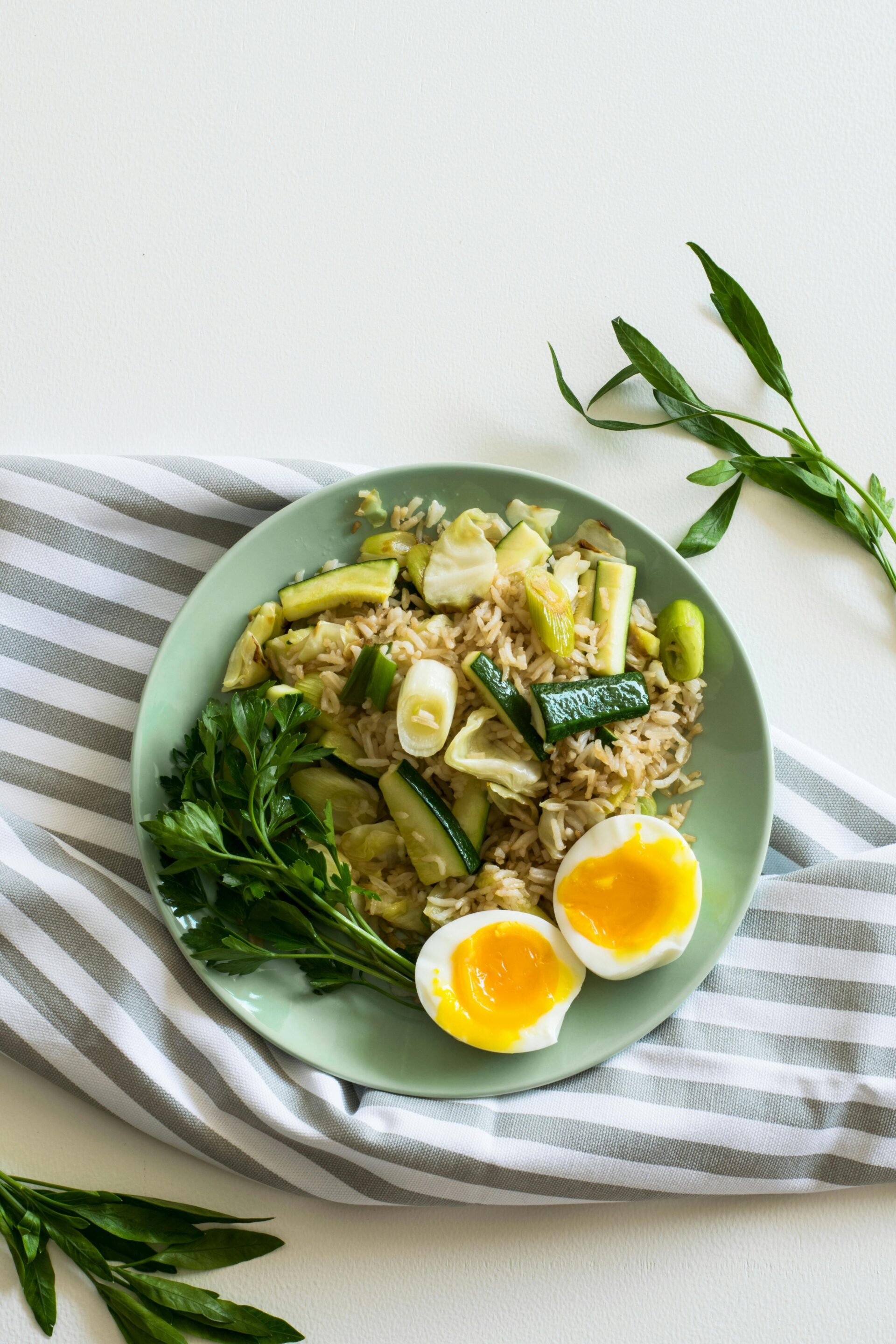 rice-with-zucchini-soft-boiled-egg-and-parsley-in-green-ceramic-plate