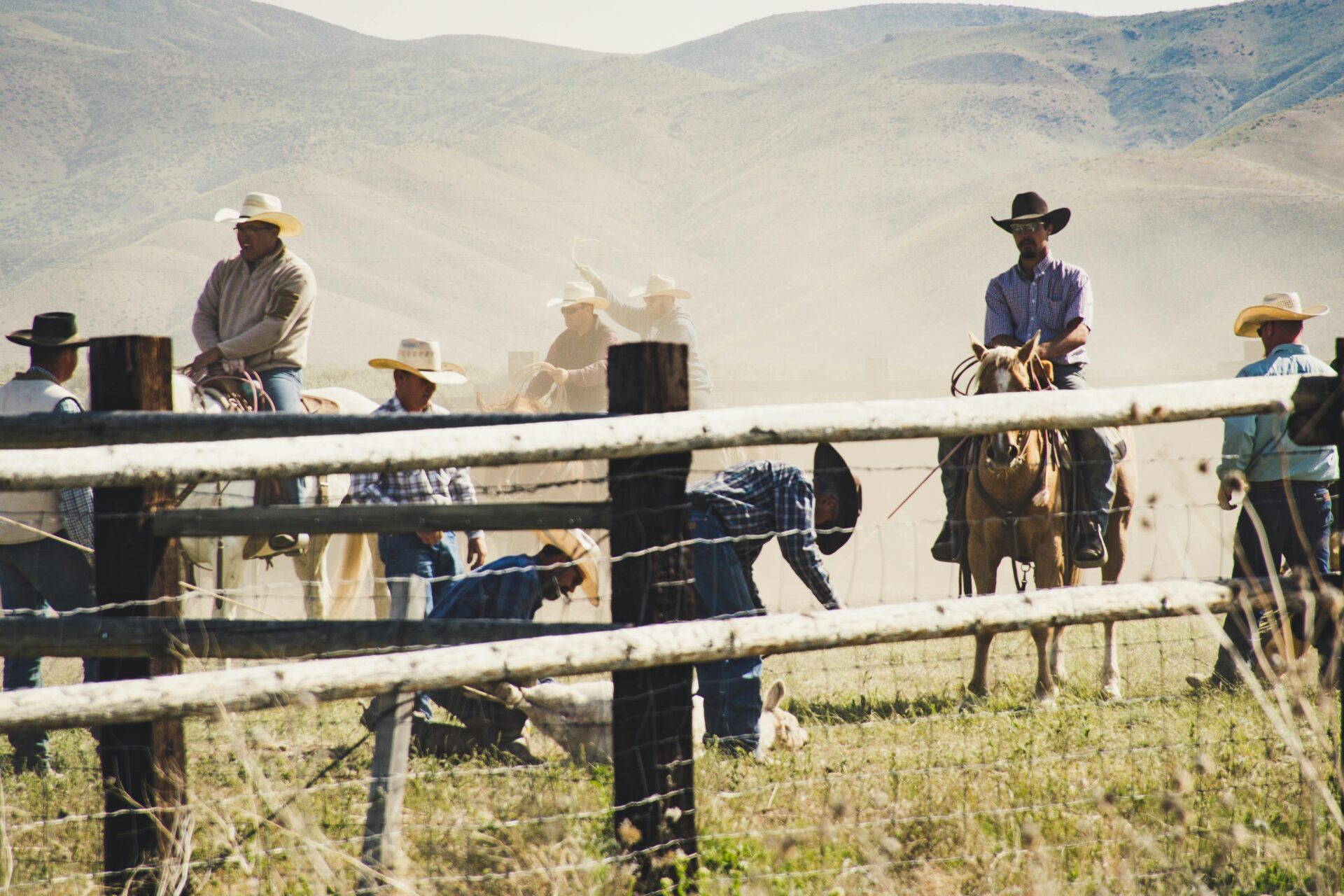 cowboys-riding-a-horse-near-gray-wooden-fence-taken-during-dayitme