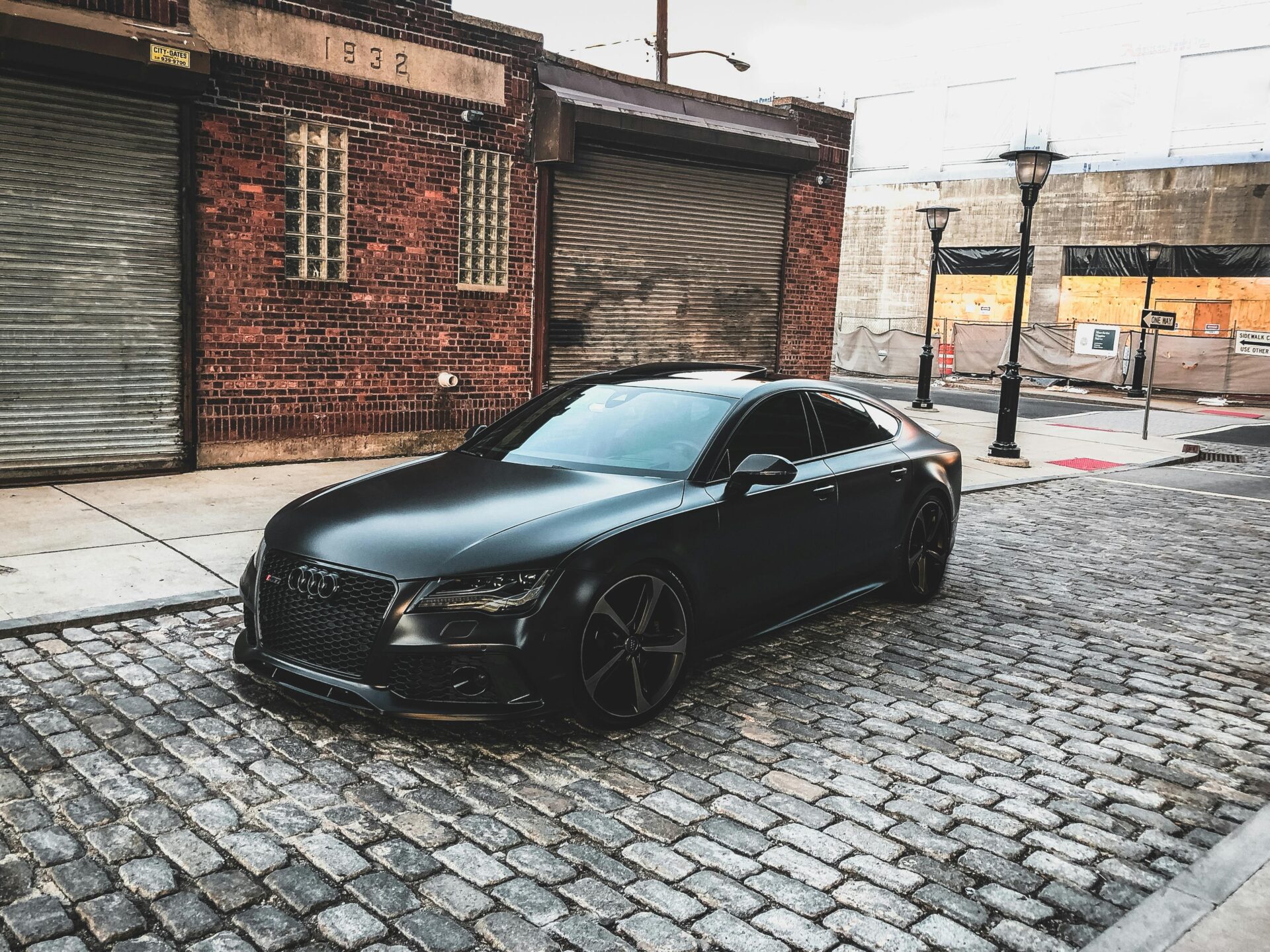 black-audi-a-series-parked-near-brown-brick-house