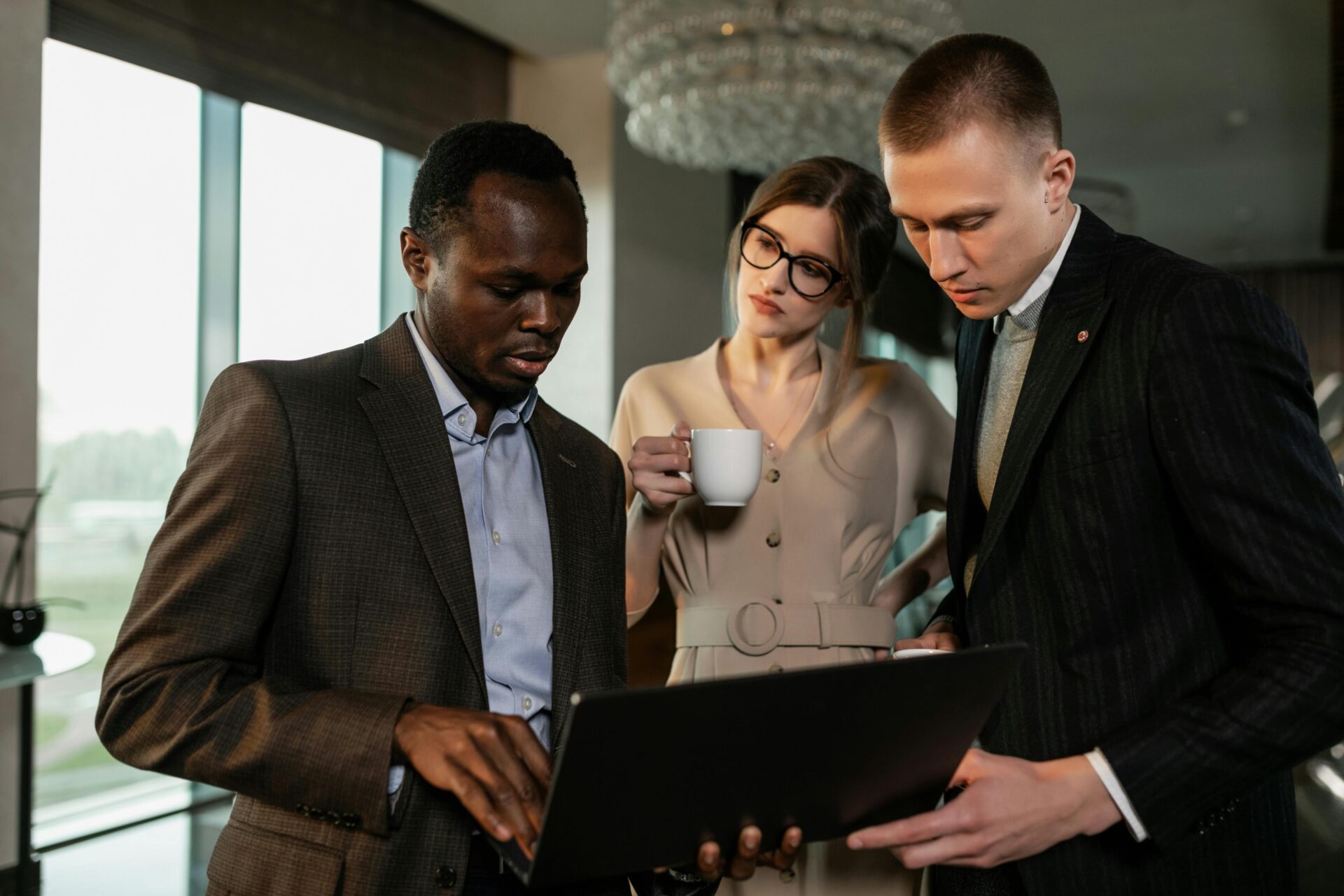 man-in-black-suit-jacket-holding-black-laptop